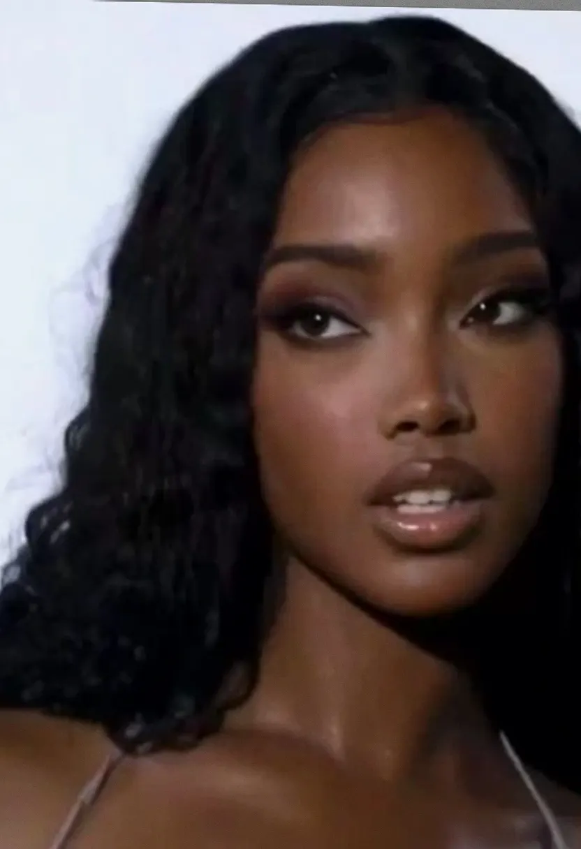 Young woman with long curly black hair against a plain white background.